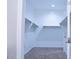 A walk-in closet featuring bright white walls, carpet, and shelves with hanging racks at 1255 N Arizona Ave # 1216, Chandler, AZ 85225