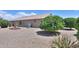 Backyard with a fire pit, mature trees, and gravel ground cover, creating a low-maintenance outdoor space at 135 S Verde Ln, Casa Grande, AZ 85194