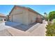 View of the side of the house with a 2-car garage and a brick walkway to an iron gate at 135 S Verde Ln, Casa Grande, AZ 85194