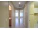 Hallway with doors leading to bathroom, rooms, and laundry, tile floor and neutral walls at 135 S Verde Ln, Casa Grande, AZ 85194