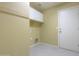Bright laundry room featuring white storage cabinets and a door to the exterior at 135 S Verde Ln, Casa Grande, AZ 85194