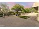Scenic backyard featuring desert landscaping, artificial turf, and a cozy seating area beneath a large, mature shade tree at 14945 N 102Nd St, Scottsdale, AZ 85255
