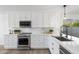 Modern kitchen with stainless steel appliances, white cabinets, and elegant quartz countertops at 14945 N 102Nd St, Scottsdale, AZ 85255