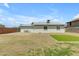 Backyard featuring a square patch of green turf and a stone patio area at 1511 E Harmony Ave, Mesa, AZ 85204