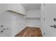 Well-lit pantry featuring open wooden shelves, and durable wood-look vinyl flooring at 1511 E Harmony Ave, Mesa, AZ 85204