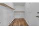 Well-lit pantry featuring open wooden shelves, with durable wood-look vinyl flooring at 1511 E Harmony Ave, Mesa, AZ 85204