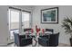 Stylish dining area with a glass table, blue chairs, and a view to the outdoor patio at 1539 W Puget Ave, Phoenix, AZ 85021