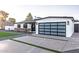 A modern house with black window frames, a glass garage door, and minimalist landscaping at 1539 W Puget Ave, Phoenix, AZ 85021