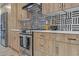 Close up of modern kitchen with stainless steel appliances, wood cabinets, and unique patterned backsplash at 1539 W Puget Ave, Phoenix, AZ 85021