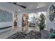 Modern living room with grey wood floors, an area rug and an open view to the kitchen at 1539 W Puget Ave, Phoenix, AZ 85021