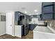 Kitchen featuring modern appliances, stylish countertops, and custom blue cabinetry at 1828 W Tuckey Ln # 13, Phoenix, AZ 85015