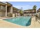 Community pool surrounded by fence, multi-story residential buildings, with lounge chairs at 1828 W Tuckey Ln # 13, Phoenix, AZ 85015