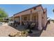 Spacious back patio featuring comfortable seating, a dining area, and a well-manicured gravel landscape at 20394 N Coronado Way, Surprise, AZ 85374