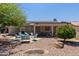 Charming backyard featuring patio seating, mature landscaping, and desert rock at 20394 N Coronado Way, Surprise, AZ 85374