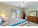 Light-filled bedroom with a ceiling fan, windows, and a cozy quilt on the bed at 20394 N Coronado Way, Surprise, AZ 85374