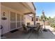 Welcoming covered patio with a dining set and a view of the meticulously landscaped yard at 20394 N Coronado Way, Surprise, AZ 85374