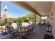 Inviting covered patio featuring stylish seating and a beautiful, well-maintained backyard landscape at 20394 N Coronado Way, Surprise, AZ 85374
