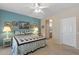 Bedroom with a serene blue accent wall, featuring soft lighting and doorway leading to the ensuite at 20394 N Coronado Way, Surprise, AZ 85374