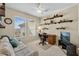 Cozy home office featuring natural light, neutral colors, built-in shelves, and a comfortable seating area at 20394 N Coronado Way, Surprise, AZ 85374