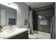 Bathroom featuring dark cabinets, quartz countertops, decorative mirrors, and a shower/tub combo at 2142 E Turney Ave # 9, Phoenix, AZ 85016