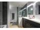 Modern bathroom with dual sinks, stylish lighting, decorative mirrors, and a frameless glass shower at 2142 E Turney Ave # 9, Phoenix, AZ 85016
