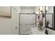 Bright bathroom featuring a glass-enclosed shower, double vanity, and modern lighting at 23404 W Burton Ave, Buckeye, AZ 85326