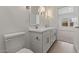 Bright bathroom with double sinks, large mirrors, and an open doorway to the bedroom at 23404 W Burton Ave, Buckeye, AZ 85326