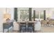 Modern dining area with a wooden table set, neutral tones, and natural light from a sliding glass door at 23404 W Burton Ave, Buckeye, AZ 85326