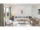 Bright living room showcasing a comfortable sofa, modern furnishings, and ample natural light from large windows at 23404 W Burton Ave, Buckeye, AZ 85326