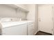 Laundry room featuring a front loading washer, dryer, white walls, and shelving at 2554 E Vermont Dr, Gilbert, AZ 85295