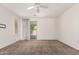 Large room featuring a ceiling fan, neutral carpet, and a glass sliding door at 2554 E Vermont Dr, Gilbert, AZ 85295