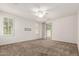 Spacious room with carpet flooring, ceiling fan, and natural light through large windows at 2554 E Vermont Dr, Gilbert, AZ 85295