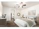 Staged main bedroom with a ceiling fan, ensuite bathroom, and contemporary decor at 2554 E Vermont Dr, Gilbert, AZ 85295