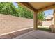 Covered patio featuring rocks, a brick sidewalk, grass, and a block wall at 2554 E Vermont Dr, Gilbert, AZ 85295