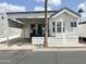 Well-maintained mobile home with covered parking and a welcoming front porch and tidy landscaping at 272 S Cinnabar Dr, Apache Junction, AZ 85119