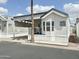 Cozy manufactured home with covered parking and a front porch, plus low maintenance landscaping at 272 S Cinnabar Dr, Apache Junction, AZ 85119