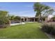Expansive backyard featuring lush artificial grass, a sparkling pool, and a covered patio with outdoor seating area at 2727 S Balboa Dr, Gilbert, AZ 85295