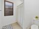 Simple bathroom featuring a window with blinds and tile flooring; a shower with white curtain is also visible at 2727 S Balboa Dr, Gilbert, AZ 85295