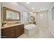 Luxurious bathroom with dual vanities, soaking tub, granite countertops, and tile flooring at 2727 S Balboa Dr, Gilbert, AZ 85295