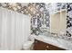 Stylish bathroom with a decorative mirror, floral wallpaper, and a shower with a white curtain at 2727 S Balboa Dr, Gilbert, AZ 85295