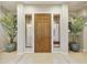 Inviting entryway with decorative tile, a wooden front door, and potted plants at 2727 S Balboa Dr, Gilbert, AZ 85295