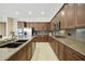 A modern kitchen features granite countertops, tile floors, custom wood cabinets, and stainless steel appliances at 2727 S Balboa Dr, Gilbert, AZ 85295