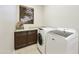 Functional laundry room featuring a washer and dryer with a countertop and cabinets for storage at 2727 S Balboa Dr, Gilbert, AZ 85295