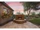 Outdoor stone fireplace with seating area complements the desert landscape, offering a cozy outdoor gathering space at 2727 S Balboa Dr, Gilbert, AZ 85295