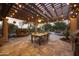 Inviting outdoor patio features a stone fireplace, dining area, and elegant pergola adorned with string lights at 2727 S Balboa Dr, Gilbert, AZ 85295