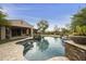 Beautiful pool with stone accents, a waterfall feature, and lush surrounding desert landscaping and well manicured greenery at 2727 S Balboa Dr, Gilbert, AZ 85295
