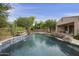 Inviting swimming pool featuring a stone waterfall, tiled accents, and mature desert landscaping at 2727 S Balboa Dr, Gilbert, AZ 85295