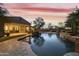 Backyard oasis featuring a stunning swimming pool and a waterfall feature under a pink sunset sky at 2727 S Balboa Dr, Gilbert, AZ 85295