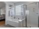 Bathroom featuring a tub, glass block window and glass enclosed shower at 29798 N 121St Dr, Peoria, AZ 85383