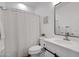 Clean bathroom with white vanity, decorative mirror, and shower with patterned curtain at 29798 N 121St Dr, Peoria, AZ 85383